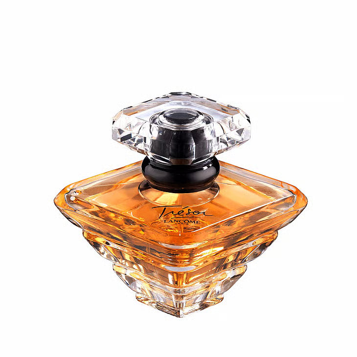 Lancôme Trésor EdP – en ikonisk diamantformad glasflaska som reflekterar en gyllene bärnstensfärgad vätska, krönt med en elegant svart ring runt halsen.