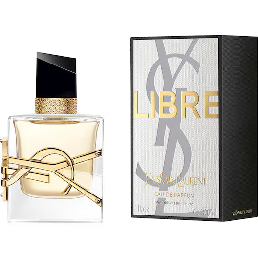 Yves Saint Laurent Libre EdP – en lyxig glasflaska med den gyllene YSL-logotypen lindad runt basen och en elegant svart asymmetrisk kork bredvid sin vit-silvriga ask.