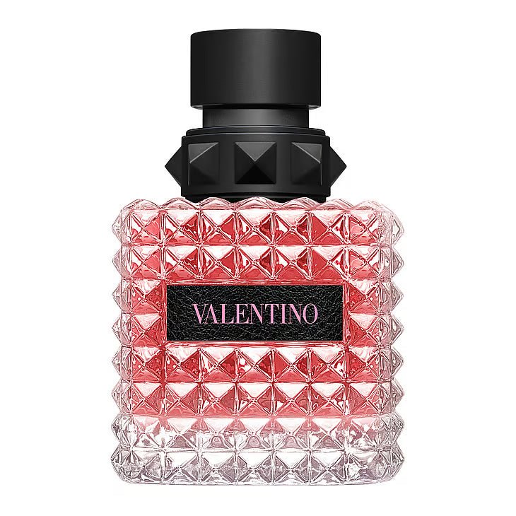 Valentino Born in Roma Donna EdP – en iögonfallande glasflaska täckt av Valentinos ikoniska nitar (rockstuds), fylld med rosa vätska och prydd med en svart kork och en svart läderetikett med rosa logotyp.