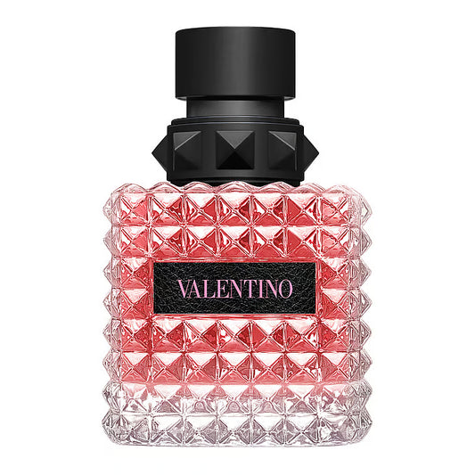 Valentino Born in Roma Donna EdP – en iögonfallande glasflaska täckt av Valentinos ikoniska nitar (rockstuds), fylld med rosa vätska och prydd med en svart kork och en svart läderetikett med rosa logotyp.